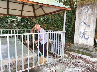 朱颂宽老人正在打扫"万人坑"遗址(沈孙晖 摄)